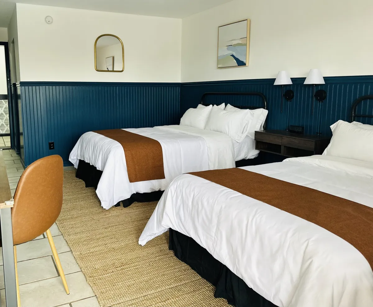 Double room with two beds, navy wainscoting and coastal styling